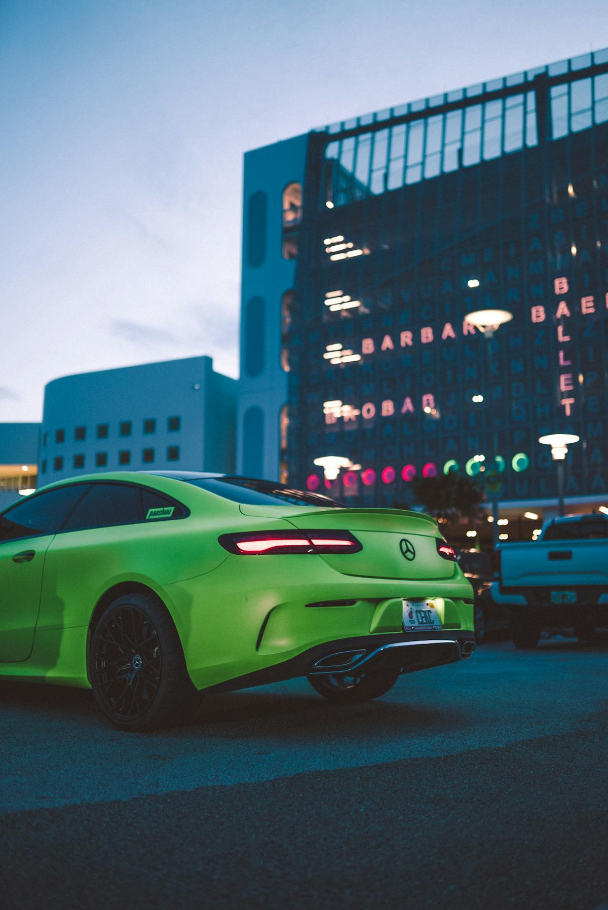 free photo of a green sports car parked in front of a modern building 2